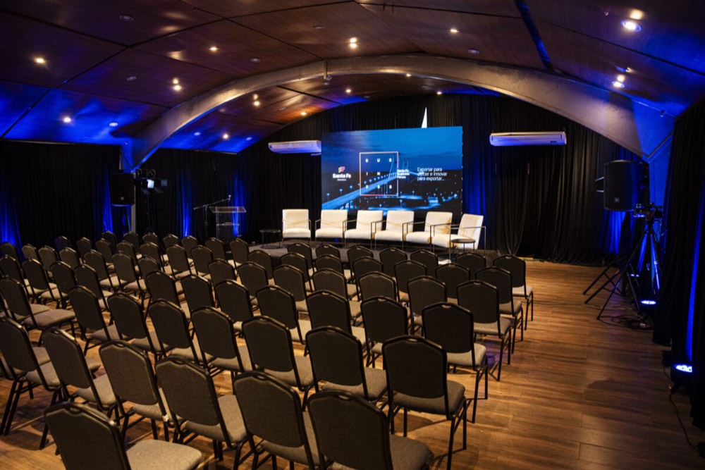 Salón Amarras configurado en formato auditorio, con pantalla y escenario