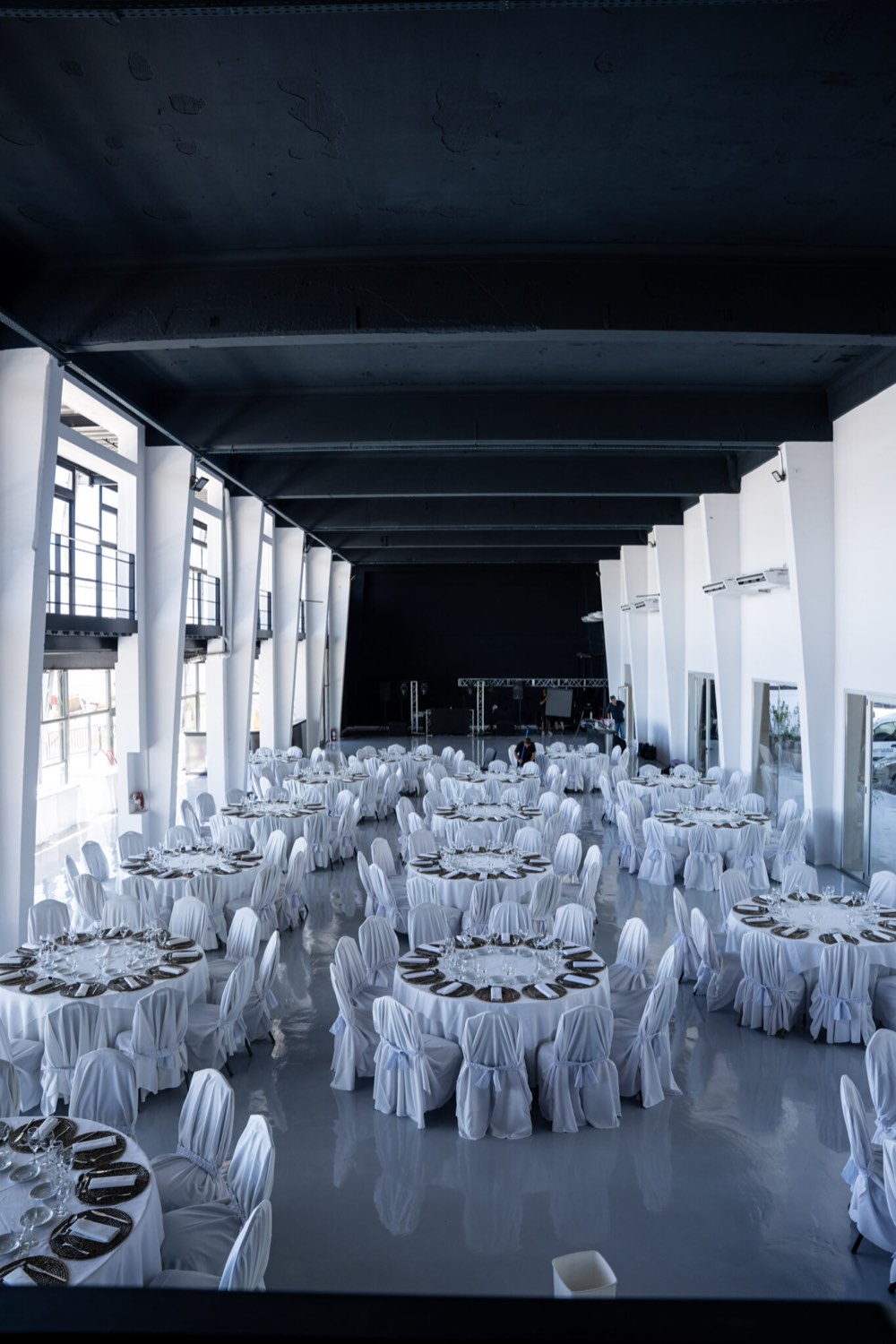 Salón Embarcadero montado para una recepción, con mesas redondas y estructura industrial a la vista
